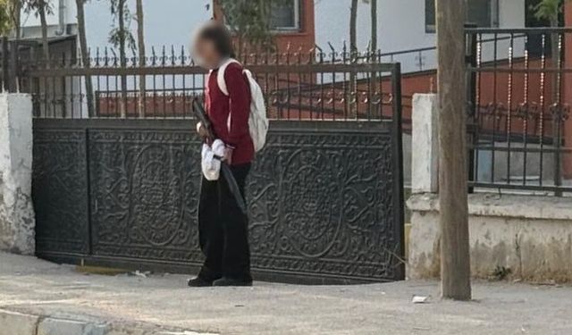 Okul kapısında eli silahlı öğrenci dikkat çekti