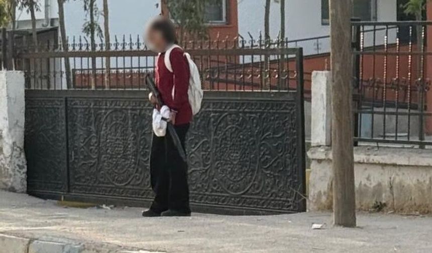 Okul kapısında eli silahlı öğrenci dikkat çekti
